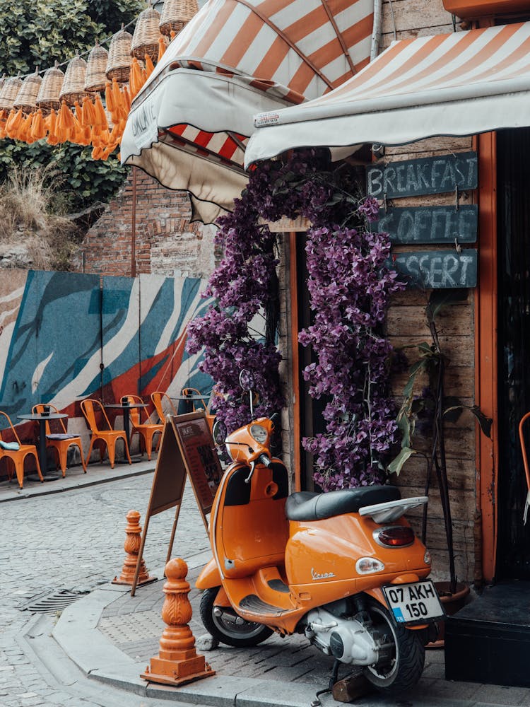 Orange Piaggio Vespa In Entrance To Cafe