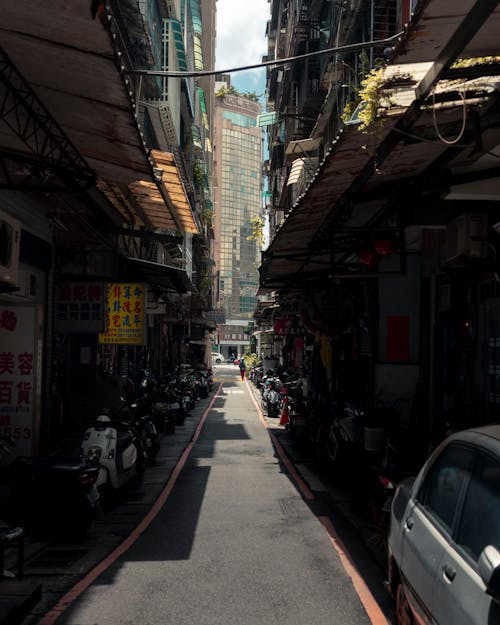 Narrow Dark Street with Parked Motor Scooters