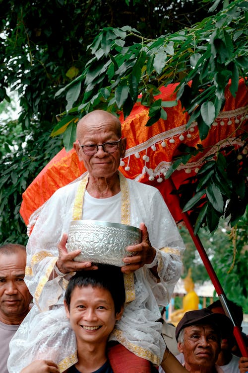 Man Carrying Piggyback Monk in Religious Procession