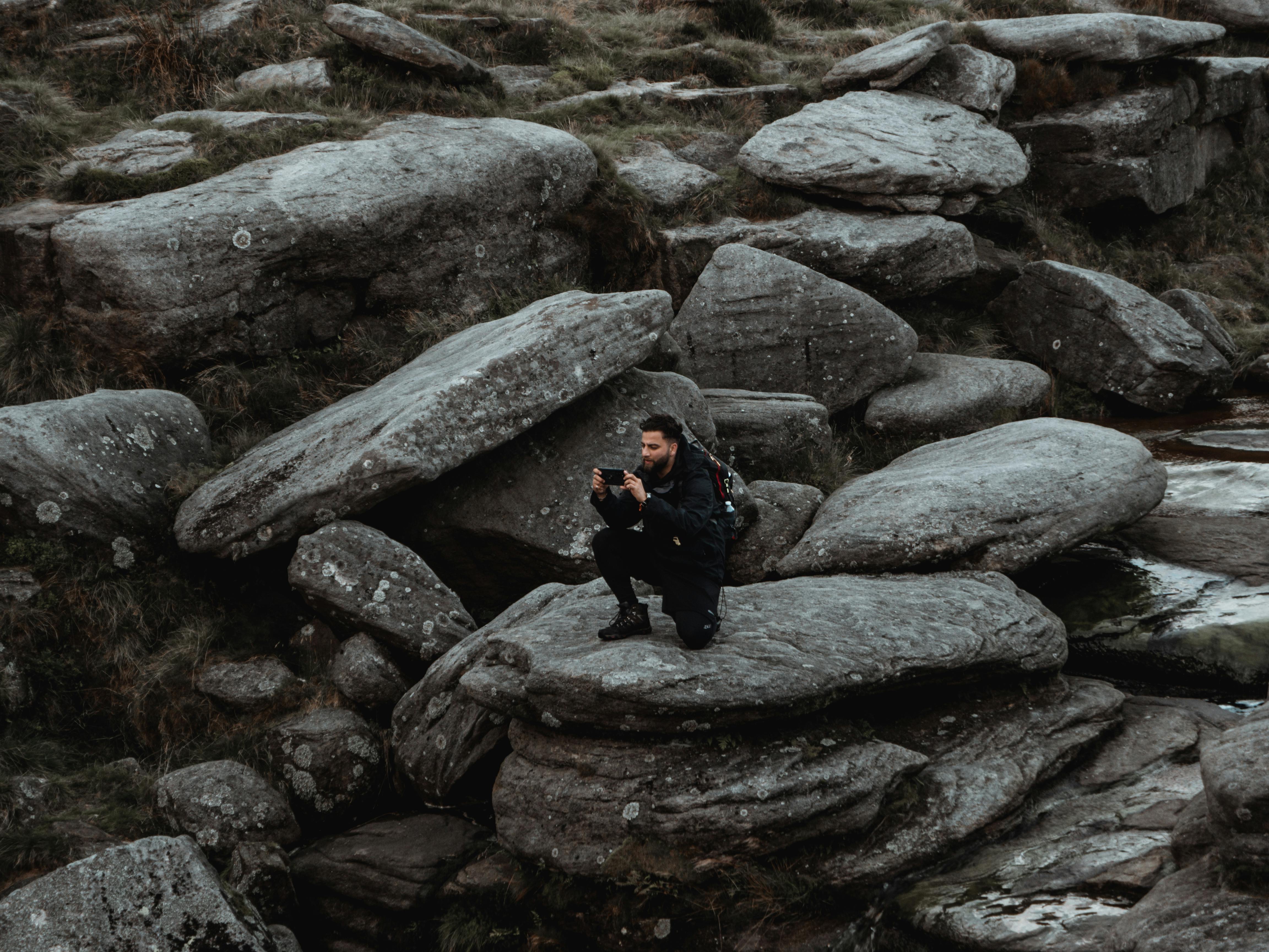 Man Kneeling on Rock and Taking Photo · Free Stock Photo