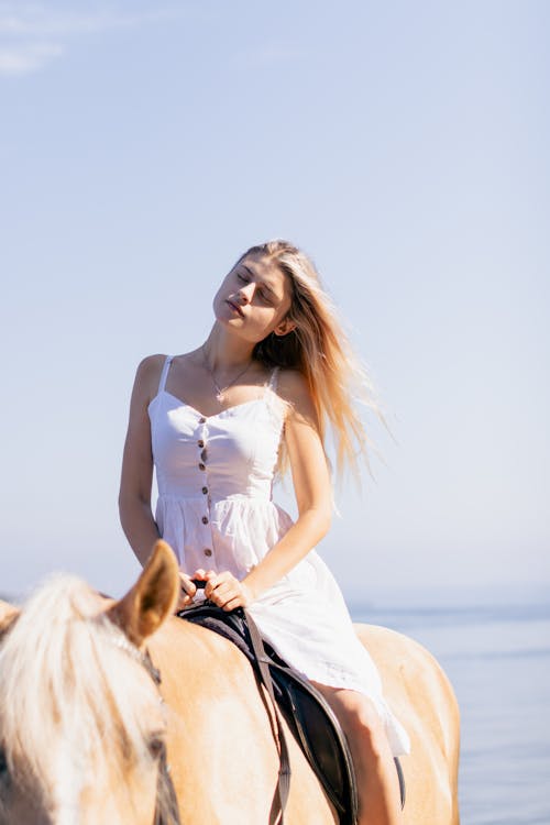 Blonde Woman Sitting with Eyes Closed on Horse