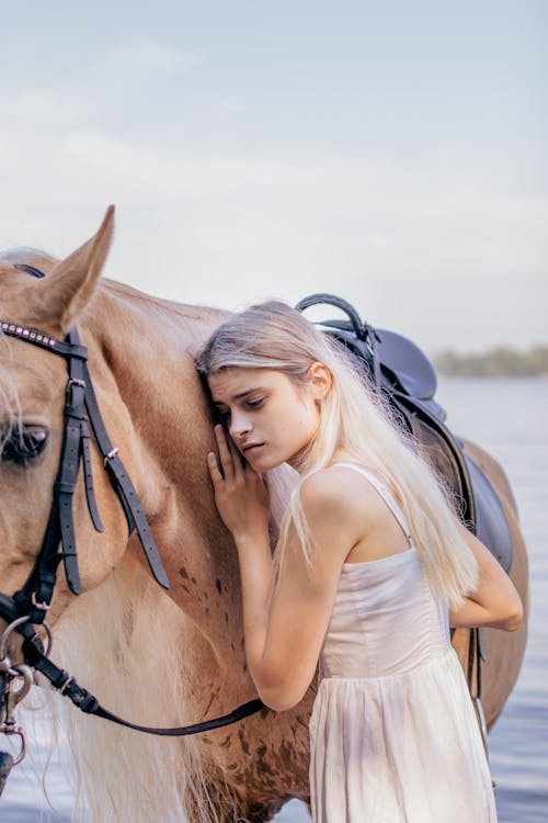 Blonde Woman in Dress Standing with Horse