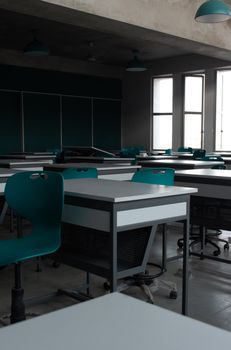 A contemporary classroom with empty desks and chairs, showcasing modern interior design.