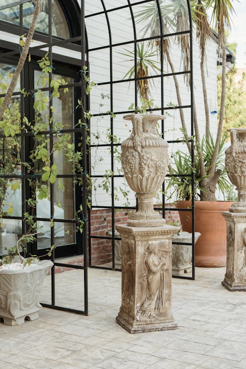 Sculptural Vases Standing at a Glasshouse Entrance