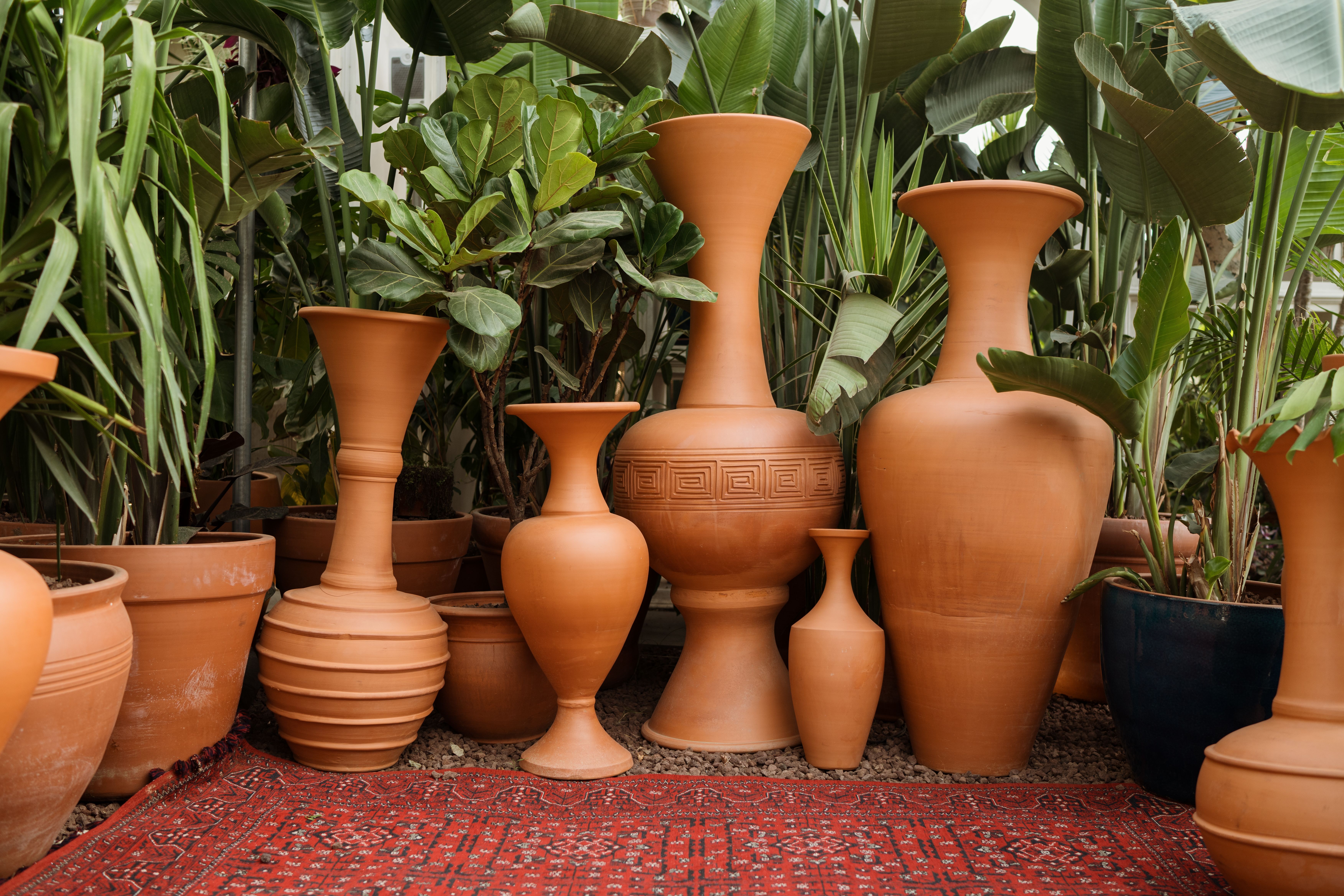 Moderne terracotta potten met geometrische patronen.