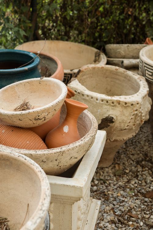 Free A collection of rustic clay flower pots arranged outdoors on gravel, ideal for gardening enthusiasts. Stock Photo
