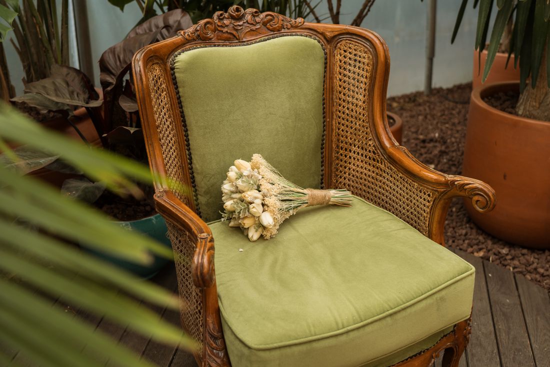 A vintage rattan armchair in a bright orangery