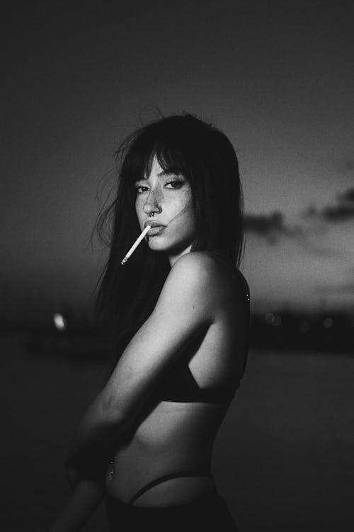 Young Woman in a Bikini Smoking a Cigarette 