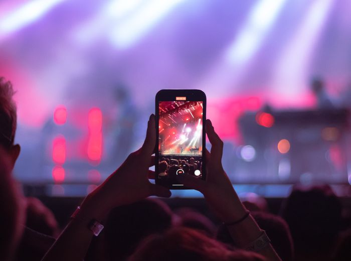 スマートフォンでライブイベントを楽しむファンのイメージ