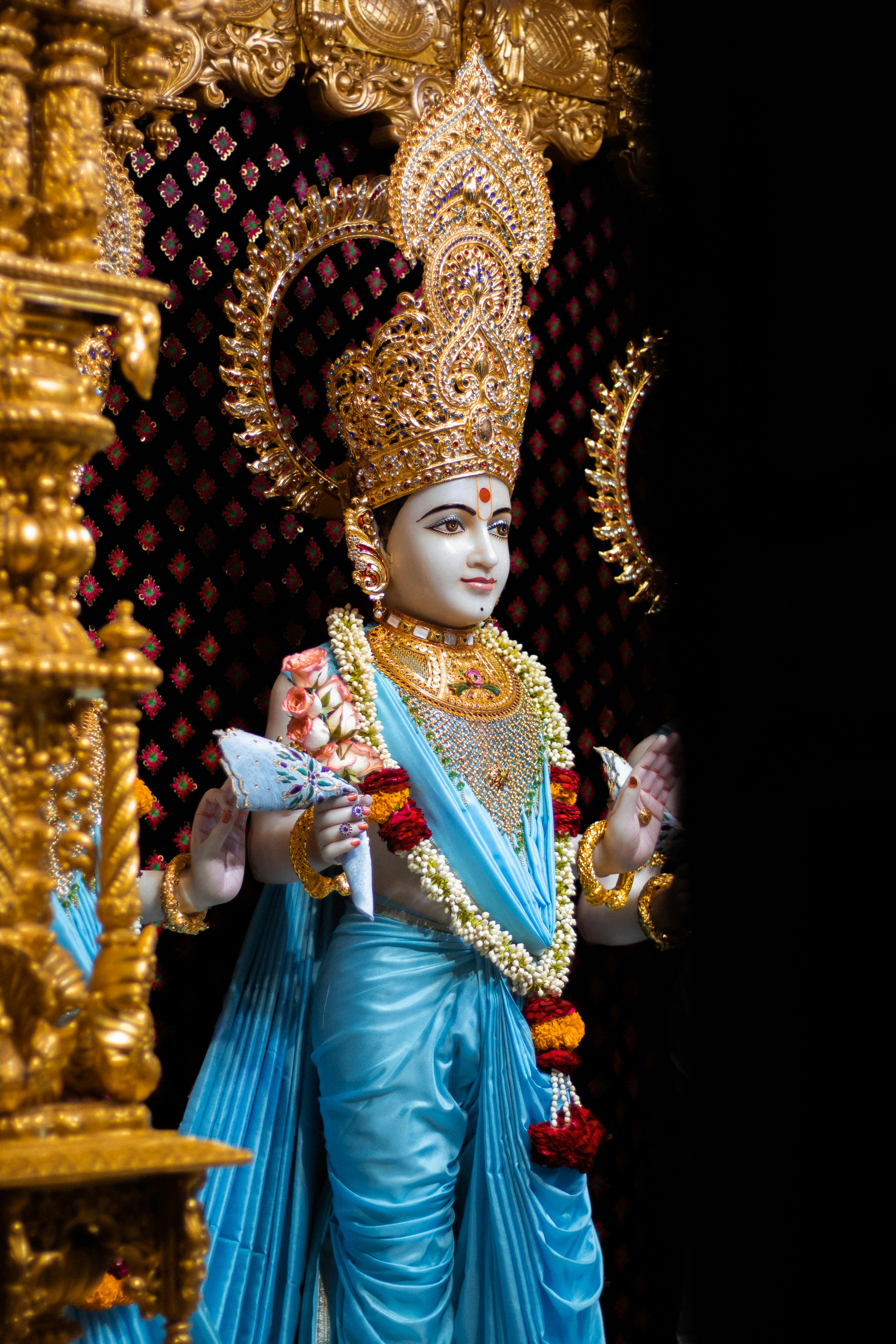 a hindu goddess statue with a crown and jewelry