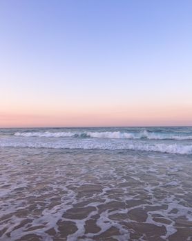 Beautiful sunrise over Gold Coast's ocean waves with pastel sky hues.