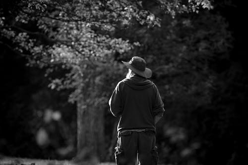 Man Wearing a Hoodie and a Sun Hat Standing Outdoors