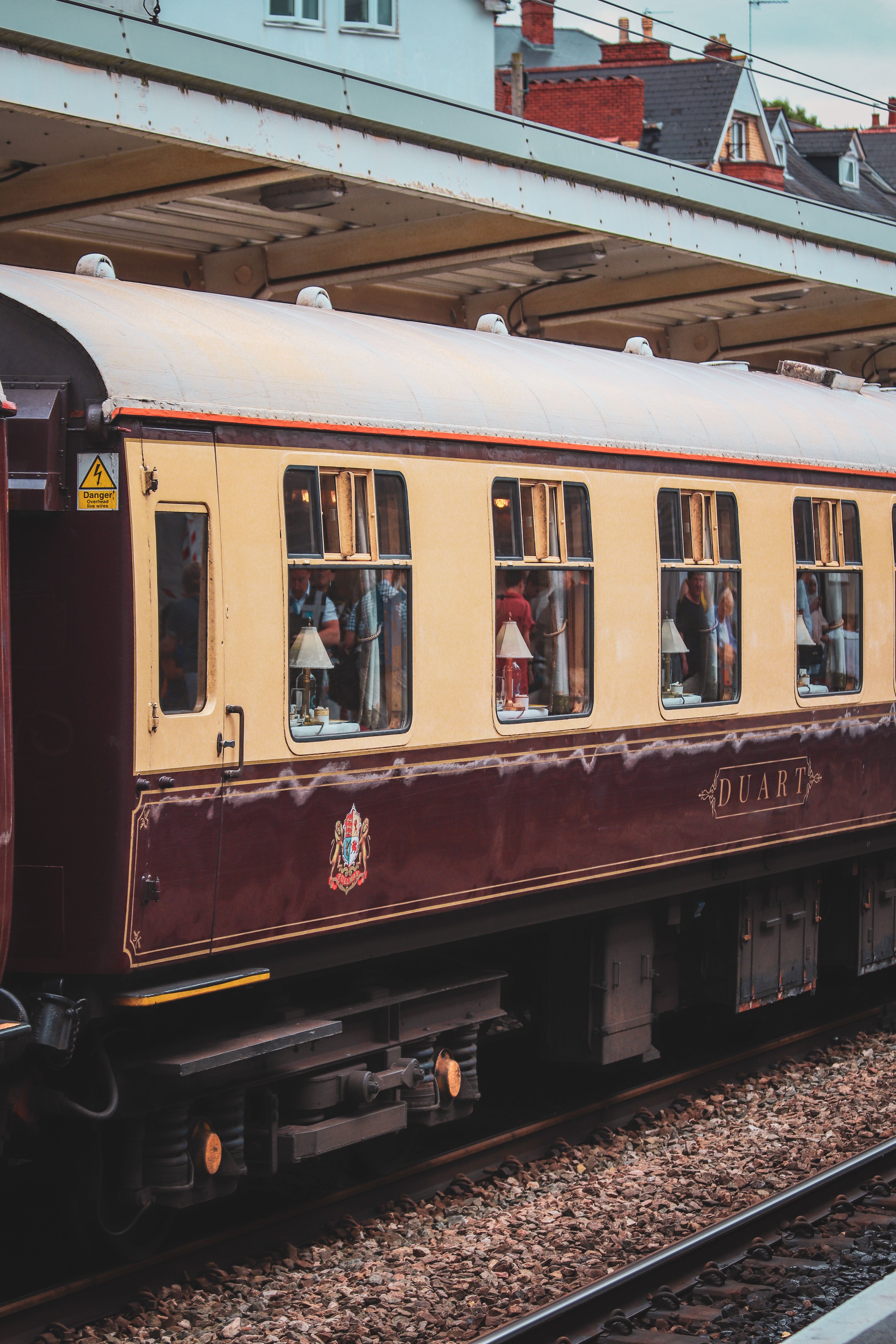 A classic vintage train carriage parked at a railway station, showcasing retro design and style.