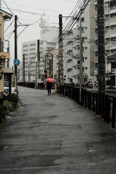 Photograph of an urban street with buildings and power lines on a rainy day.