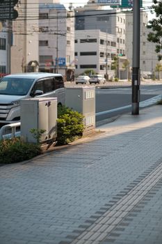 A quiet urban street view featuring sidewalks, cars, and buildings under daylight.