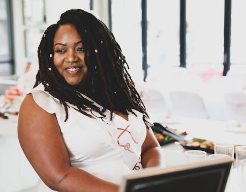 Smiling Black Woman with Dreadlocks in Restaurant 