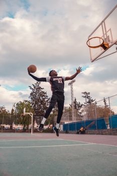 Basketball player performing a jump shot on an outdoor court in Abuja, Nigeria.