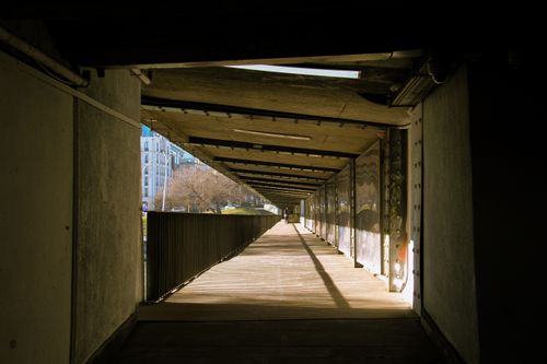 Free An urban footbridge showcasing geometric shadows and diminishing perspective in a city setting. Stock Photo