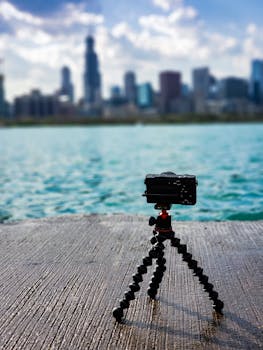 在阳光明媚的日子里，三脚架上的相机捕捉了芝加哥在平静湖面上的天际线