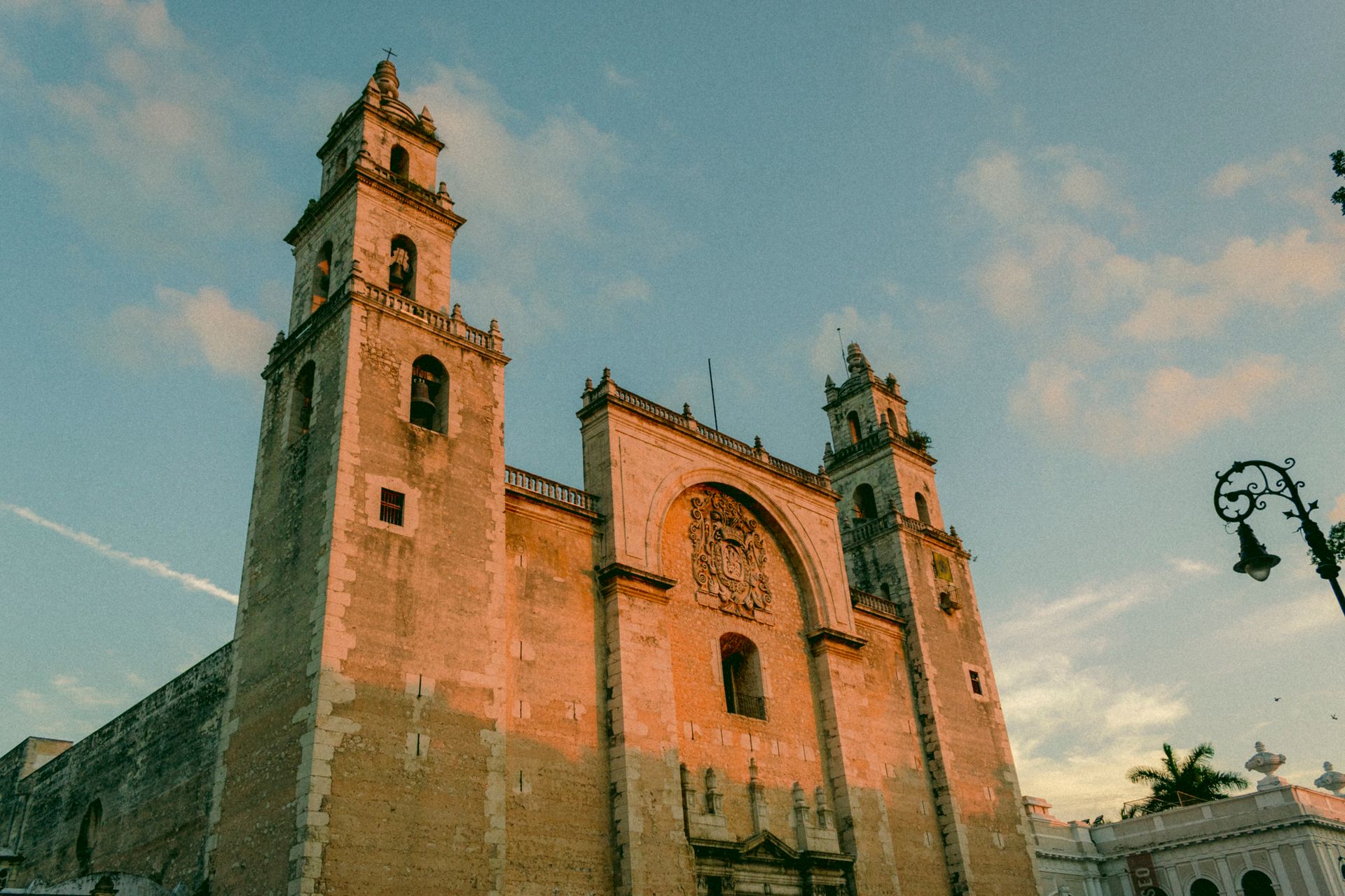 The grand facade of Mérida's iconic cathedral bathed in warm sunset light.
