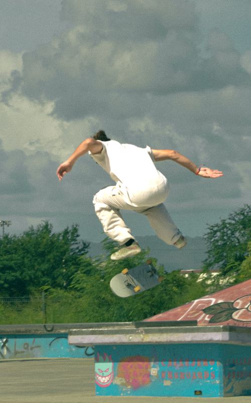 Free A skateboarder performs an aerial trick in an outdoor skate park on a bright day. Stock Photo