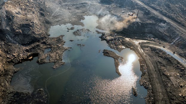 Breathtaking aerial view of a coal mine with water reflection in Dhanbad, India.