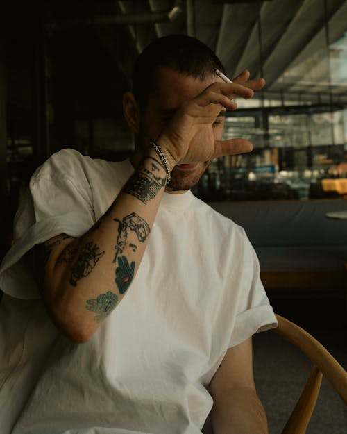 Tattooed Man Smoking a Cigarette
