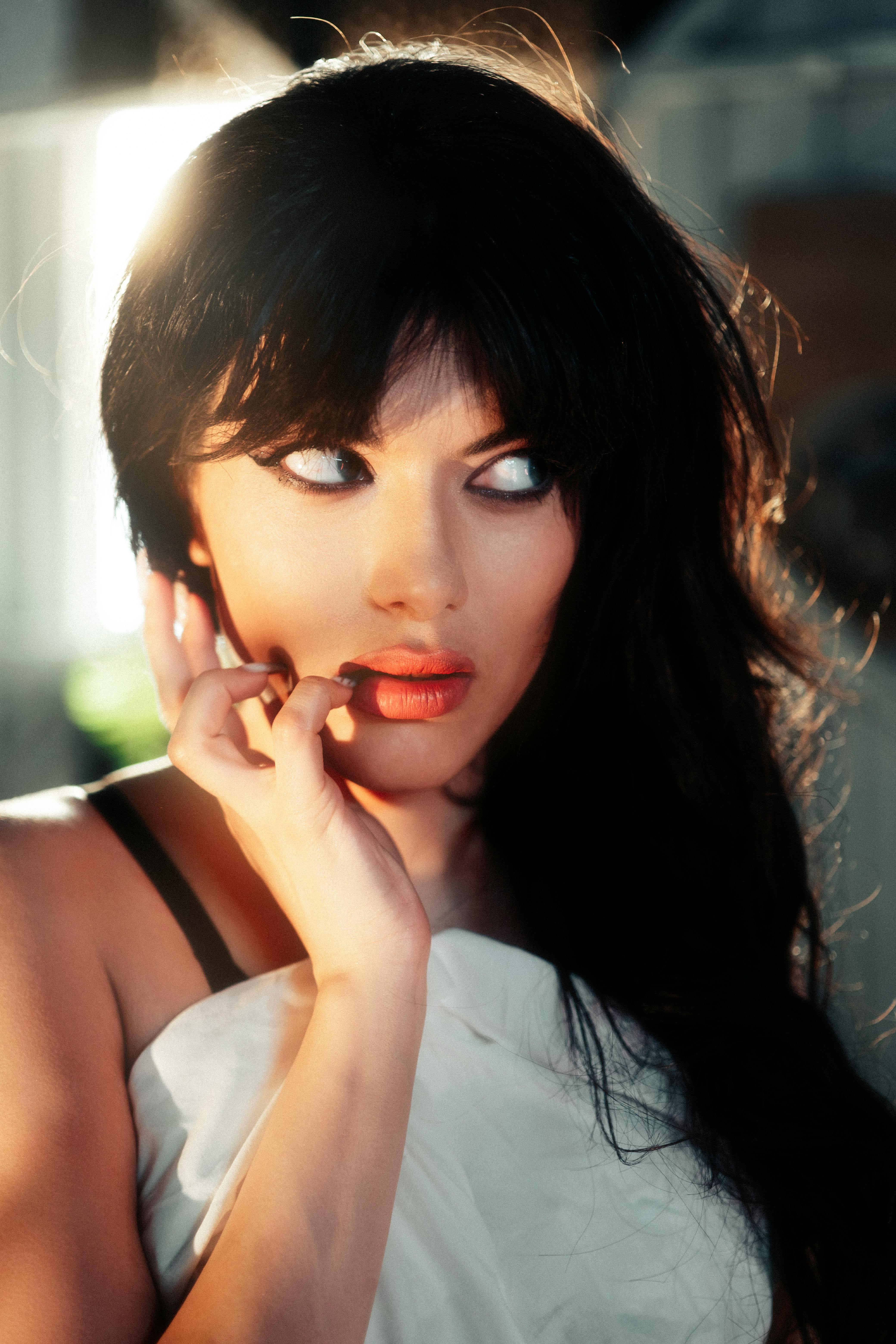 A stunning close-up portrait of a woman in soft sunlight, expressing beauty and elegance.