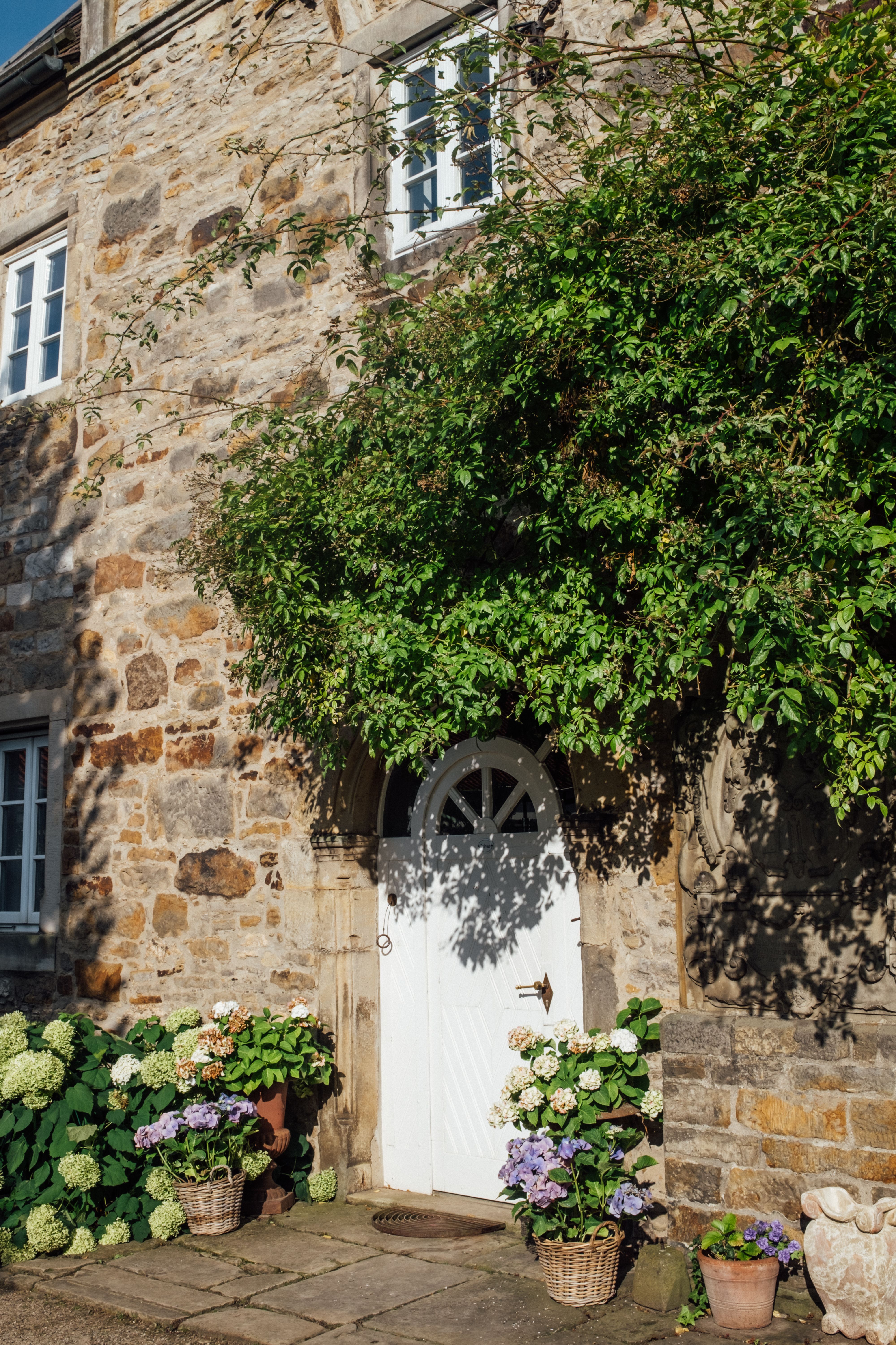 A stone house with a door and potted plants · Free Stock Photo