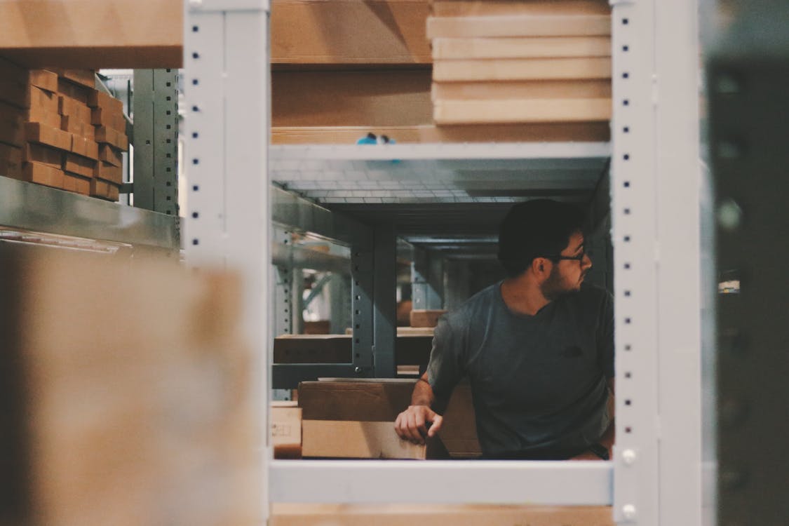 Free Man Under a Bunch of Large Shelves Stock Photo