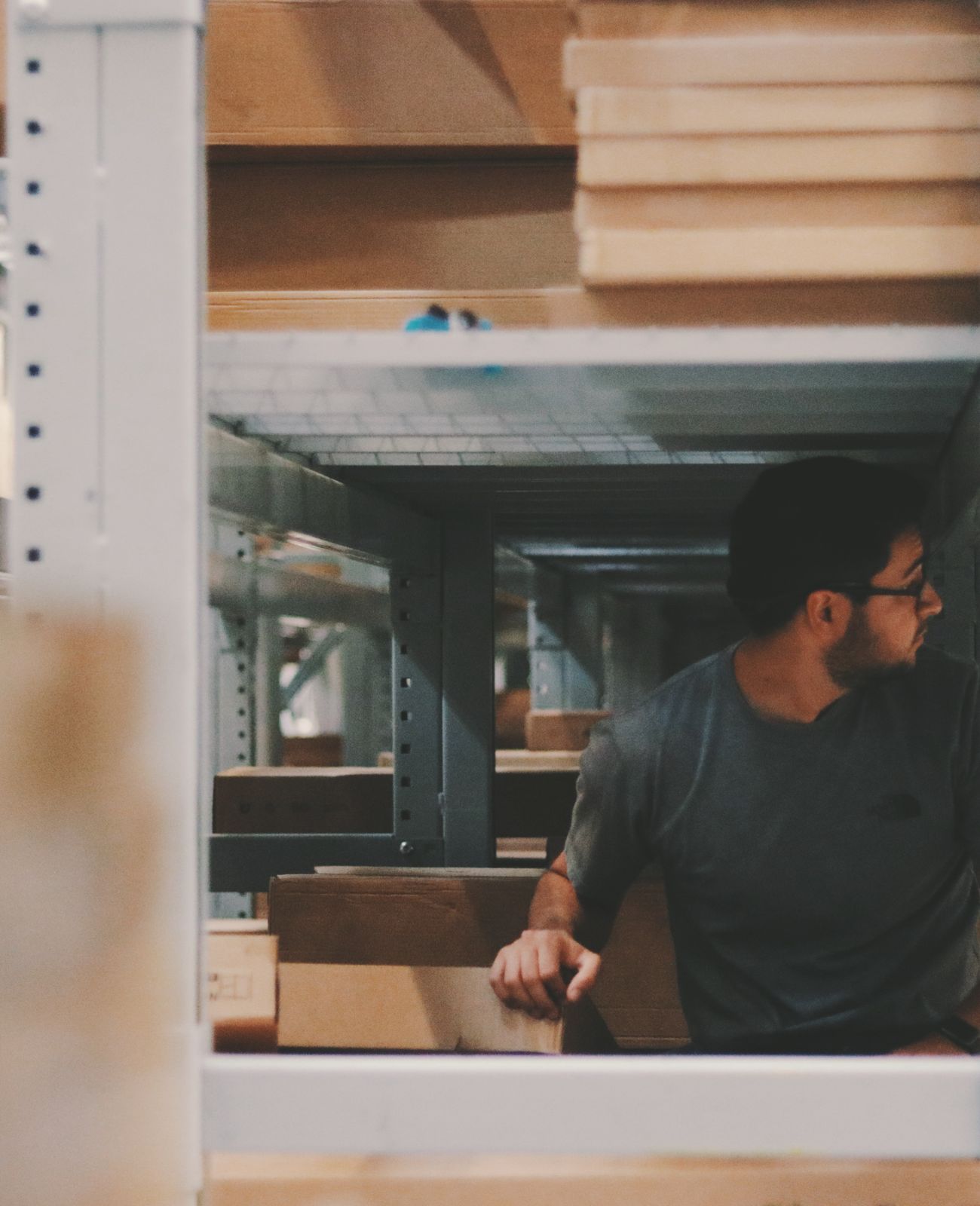 A worker moving stock between warehouse shelves