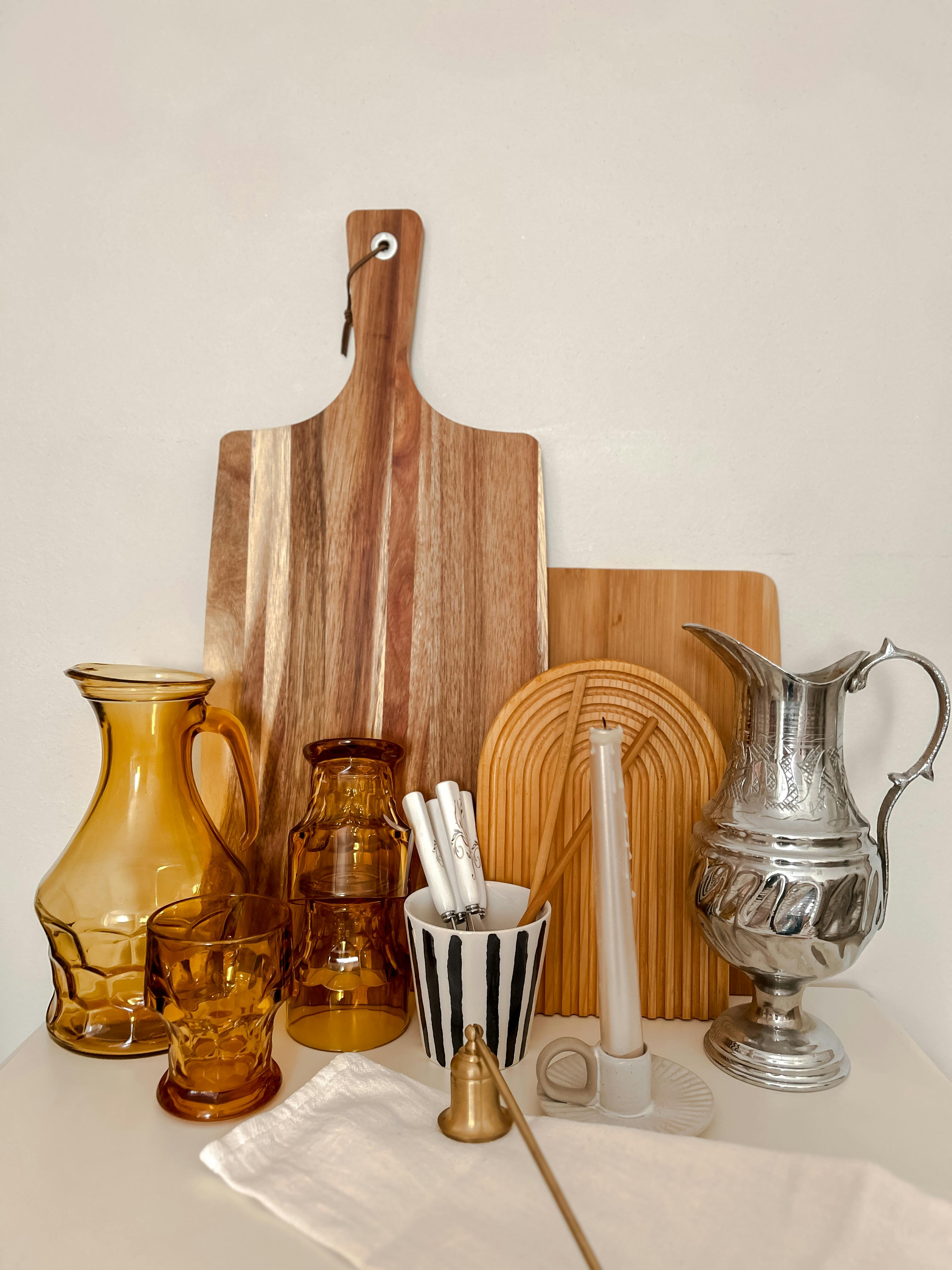A collection of rustic kitchenware including wooden boards and amber glass items on a white background.