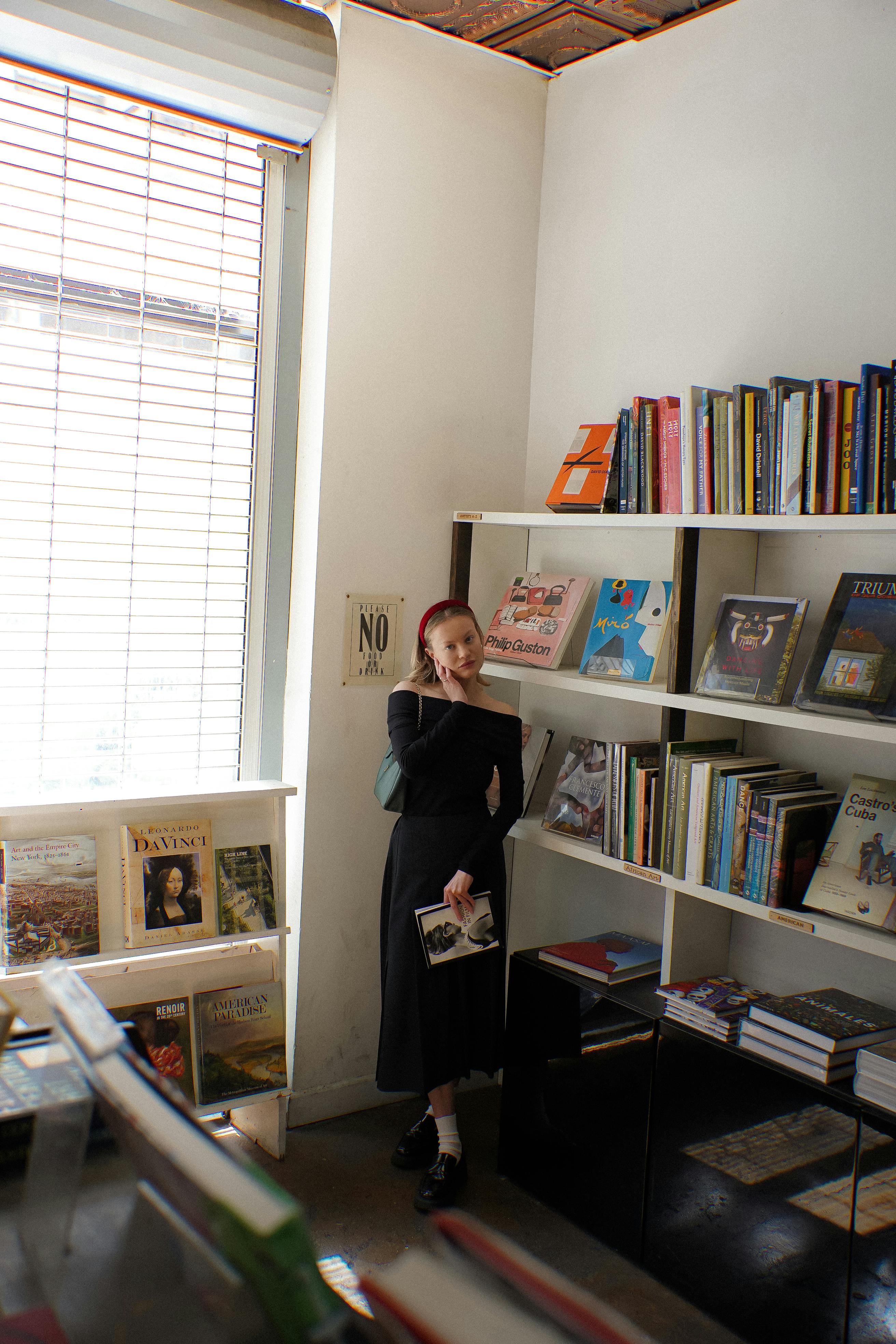 a woman standing in front of a book shelf