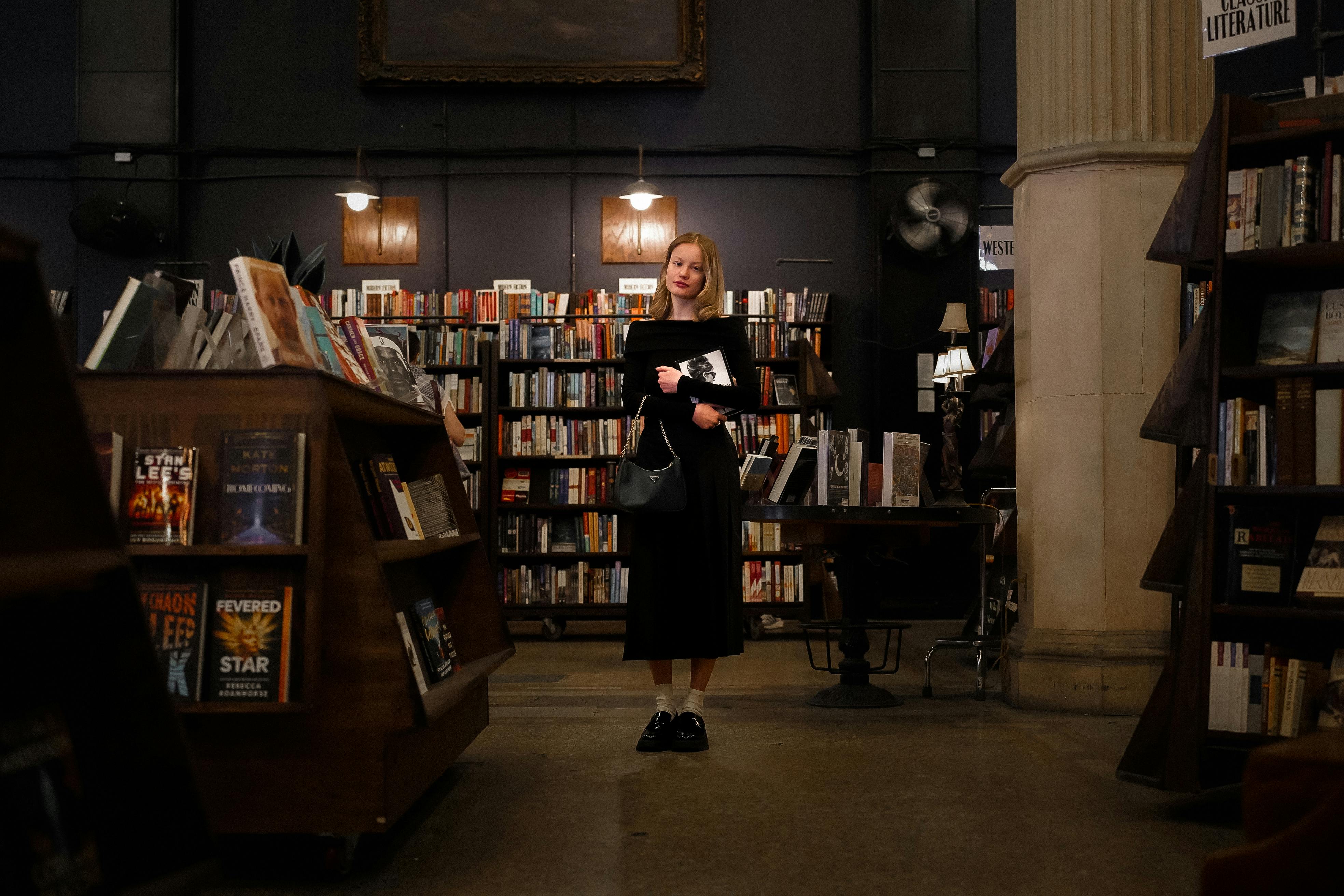 a woman standing in a bookstore with books