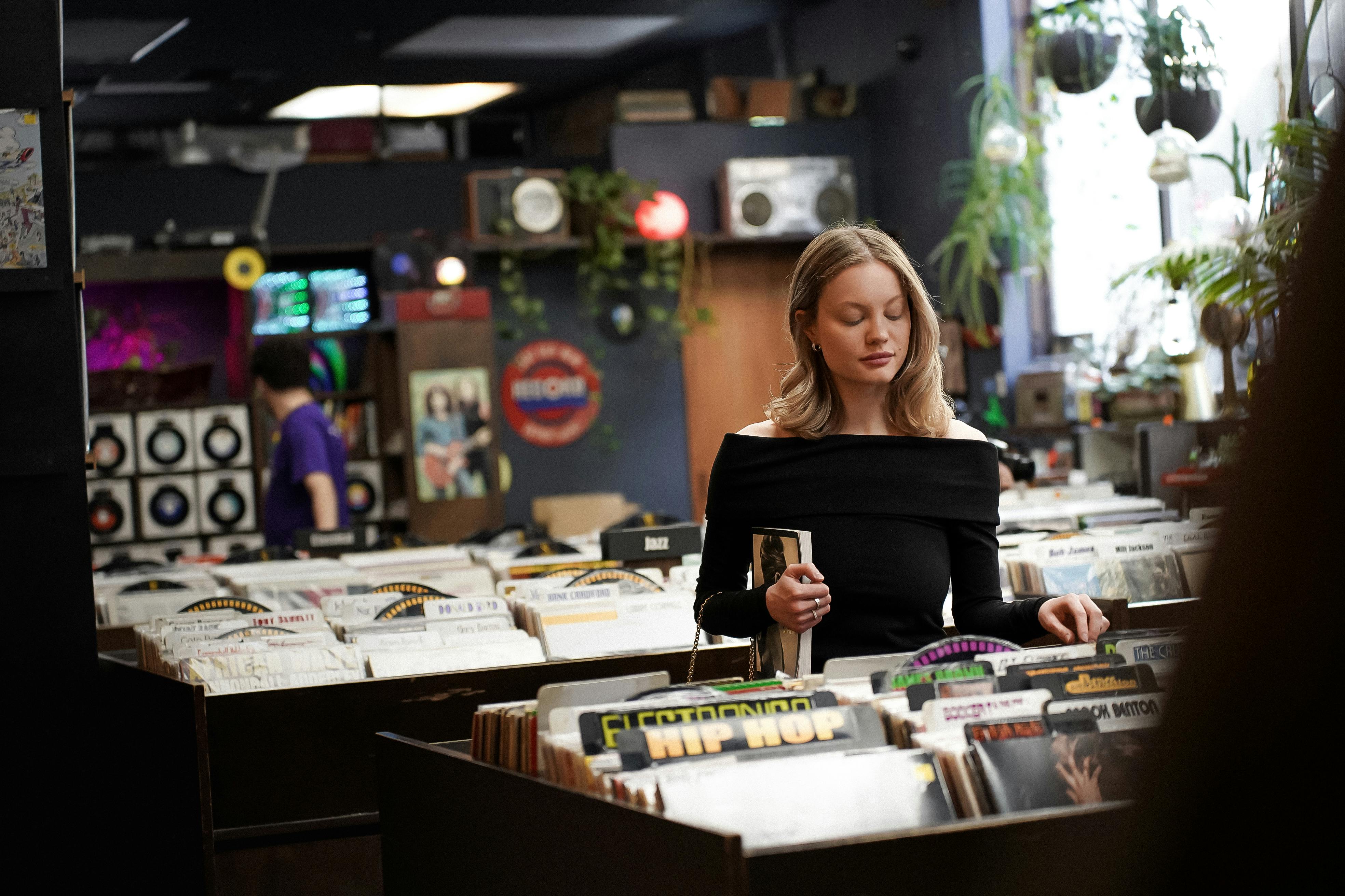 a woman standing in front of a record store