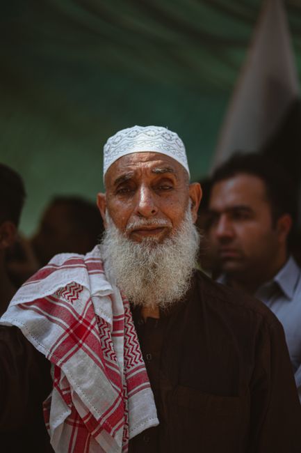 Portrait of an elderly man wearing traditional headwear and robe in Muzaffarabad.