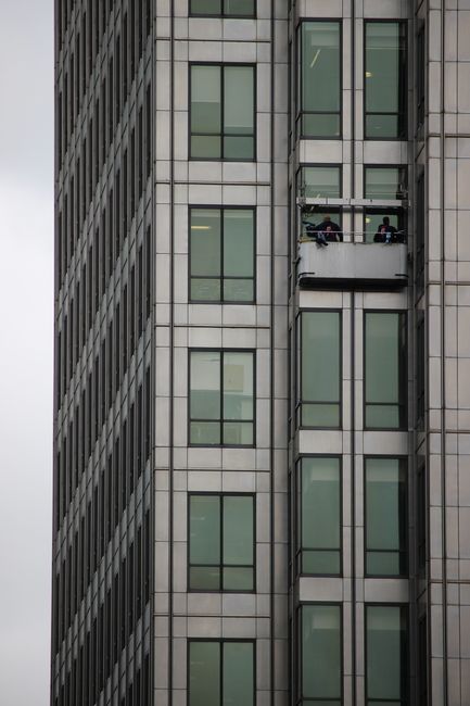 A modern skyscraper in London with a window cleaning platform on a cloudy day.