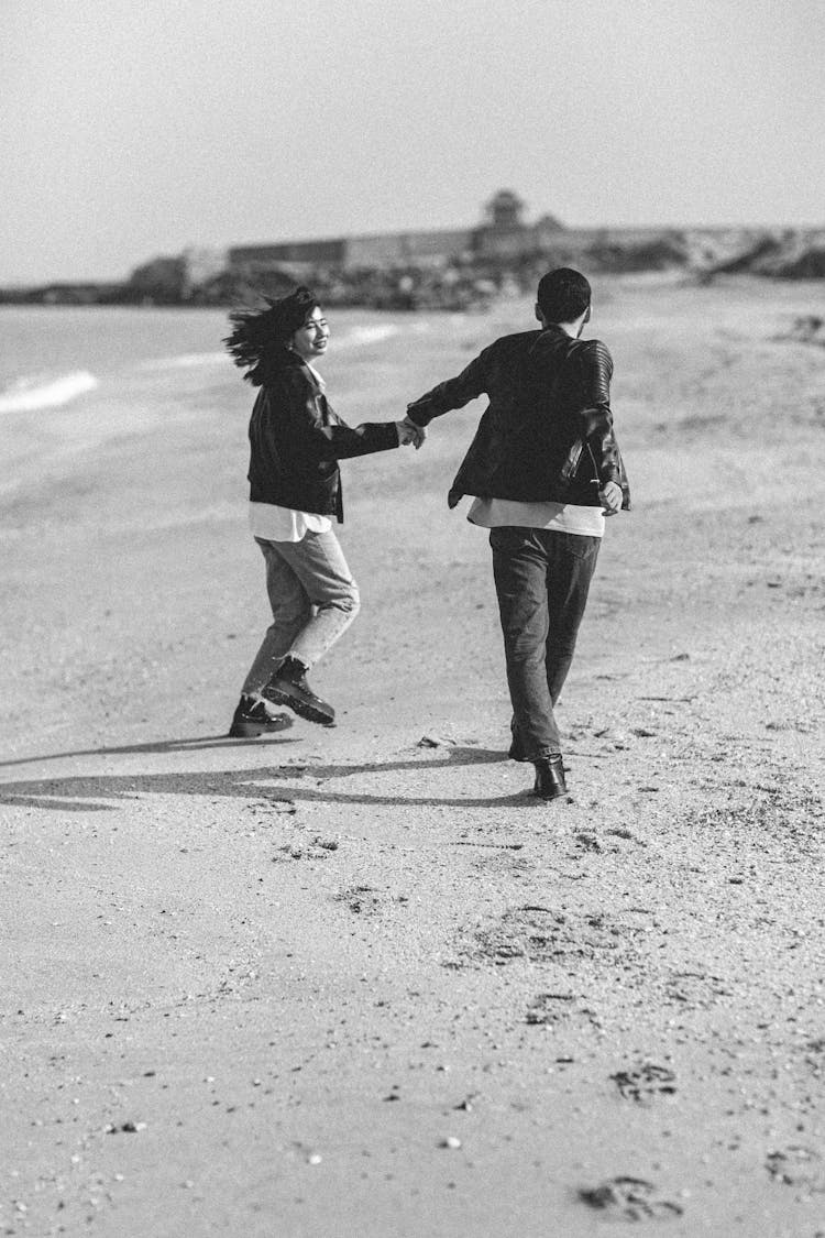 Young Couple Running On The Beach