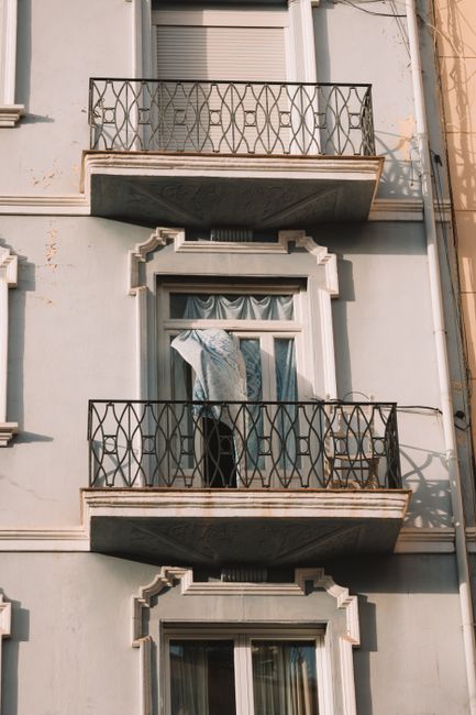 Vertical shot of a residential building facade with balconies in warm light.