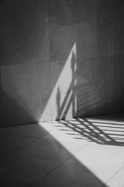 Hard shadow across a stone wall, black and white — photo by Joaquin Carfagna on Pexels