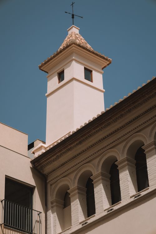 Free A low-angle view of a white church tower against a clear blue sky, showcasing architectural elegance. Stock Photo