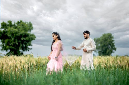 Man Following Girlfriend and Holding Her Pink Dress