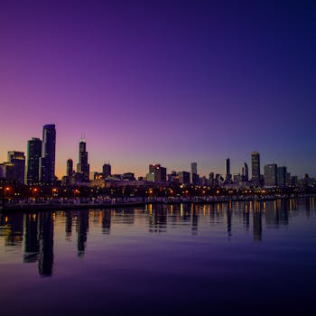 黄昏时分，芝加哥的天际线倒映在平静的河面上，天空色彩鲜艳