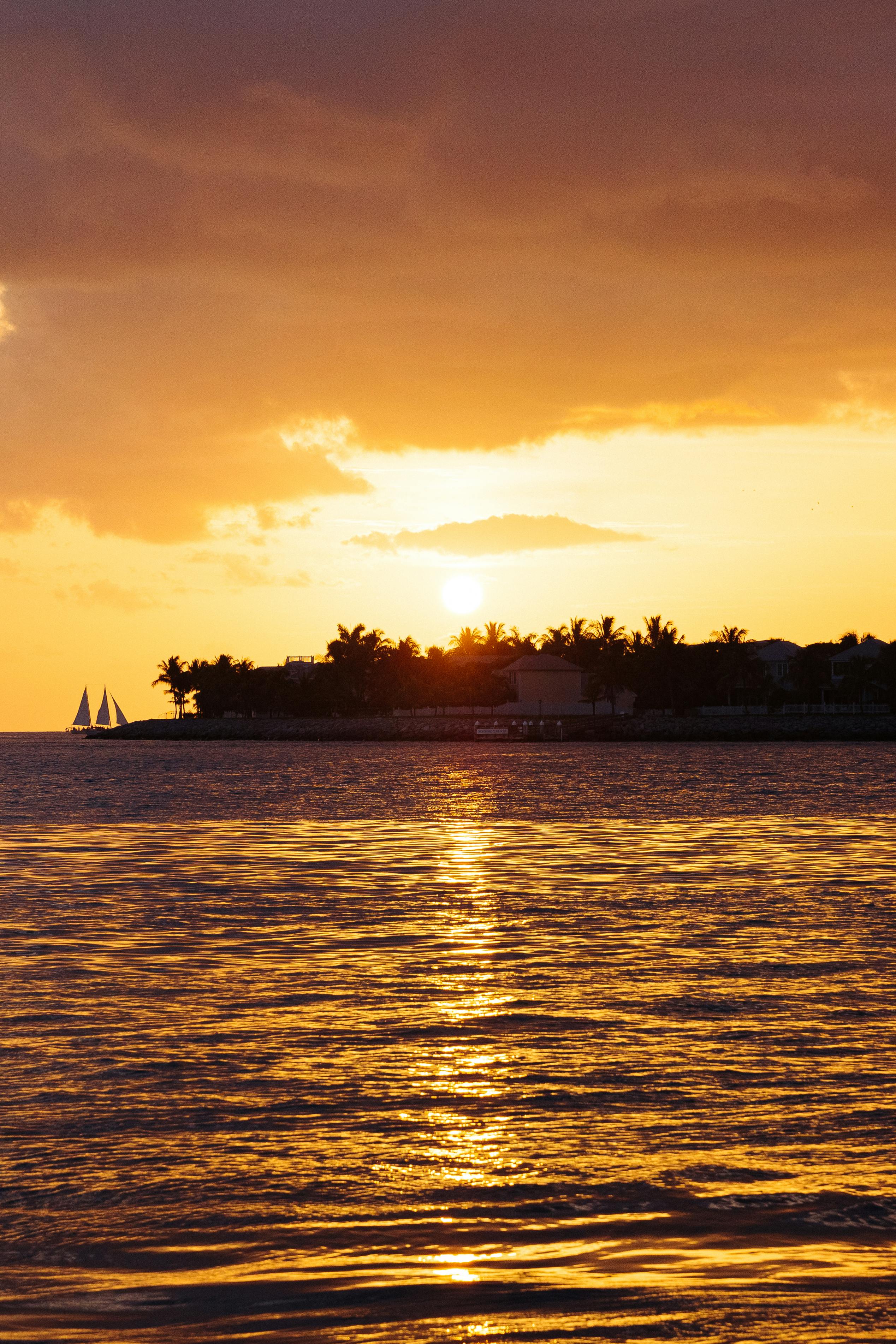 Dramatic sunset view with sailboats on the Key West horizon.