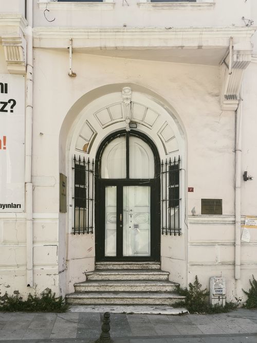 Free A stylish black arched doorway with surrounding architecture and steps leading up in an urban setting. Stock Photo