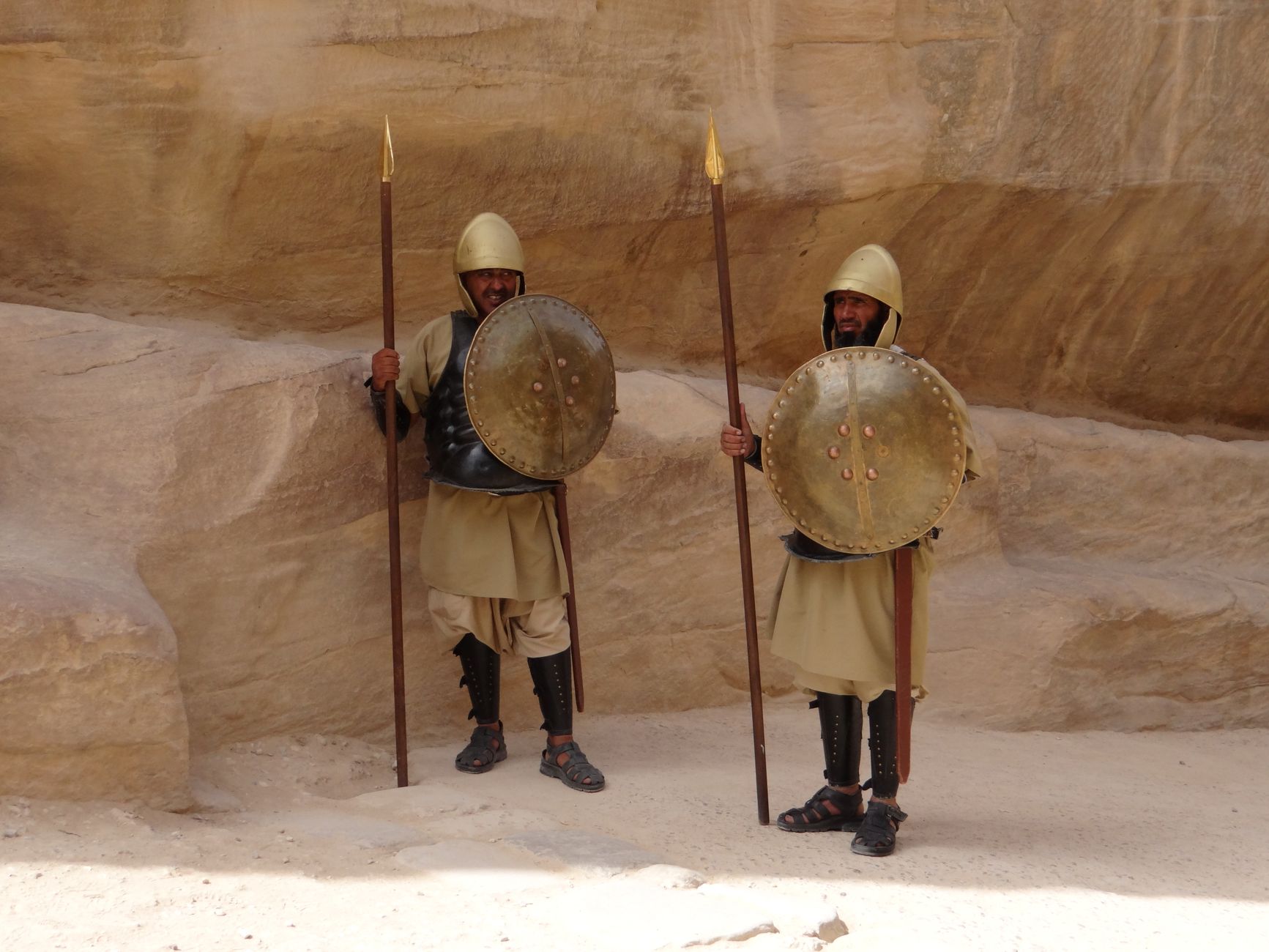 Two men in ancient armor with shields and spears at Petra, Jordan.
