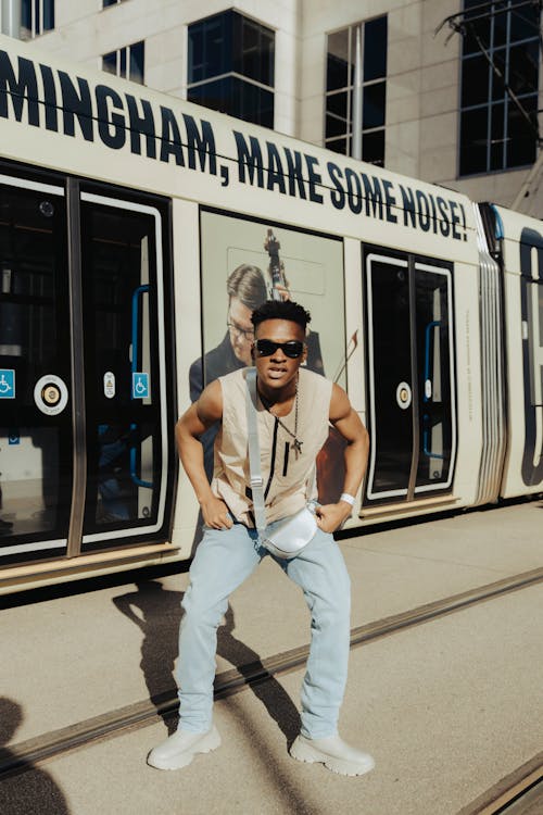 Young Man Standing in front of a Tram in City 