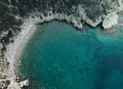 Free Stunning aerial view of a rocky coastline with clear turquoise waters in İzmir, Türkiye. Perfect for nature and travel themes. Stock Photo