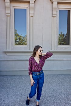 一位穿着休闲装的时尚女性在古典建筑外摆姿势