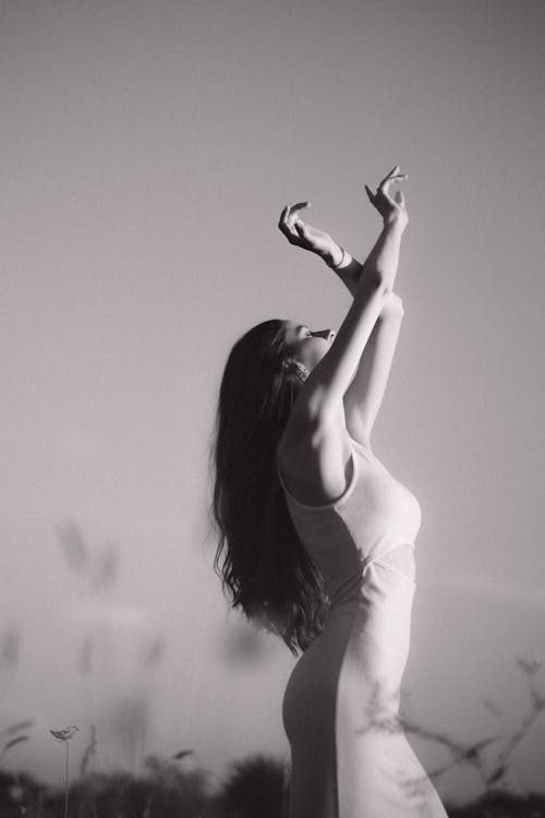 Model in a Tank Top Dress Stretching Her Arms Towards the Sun